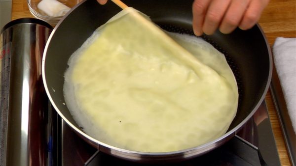When the surface begins to puff up in places and the edges begin to brown, flip the crepe over by lifting the rim with a kitchen chopstick. Be careful not to burn yourself.