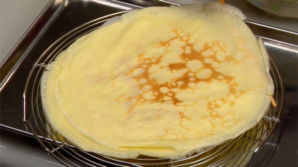 Cool the pan with the dampened towel again. Ladle the batter and repeat the process to make a stack of crepes on the cooling rack.