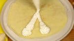 Chúng tôi sẽ làm bánh crepe dâu tây. Bóp kem đã đánh ra lên bánh crepe, thành hình chữ "V". Để bánh crepe lên đĩa phẳng với mặt có màu nâu hướng xuống.