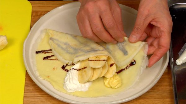 Fold the bottom third of the crepe horizontally and fold one side along the "V" shape.