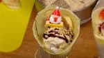アイスクリームの上にチョコレートソースをかけ、ダイスアーモンドを振りかけます。サンタクロースの飾りを挿してできあがりです。