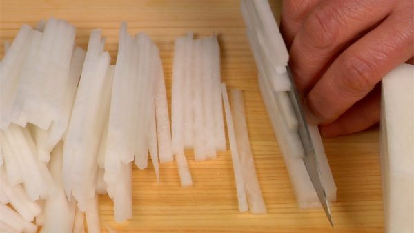 La pointe du daikon a un goût âcre donc utilisez le milieu ou la partie un peu au dessus du milieu. Utiliser le milieu du daikon permet de couper les tranches en aiguilles facilement. Placez le daikon dans un bol.