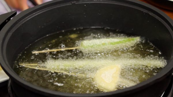 Placez les piments amanaga, les asperges et les oignons dans l'huile. Ne les touchez pas jusqu'à ce que la surface se solidifie. 