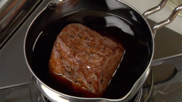 然后，将牛肉放入锅中。将其煮沸，然后将热量降低到尽可能低的水平。