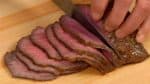 現在，從鍋中取出烤牛肉，並將其放在切菜板上。將其切成約3毫米（0.1英寸）的薄片。