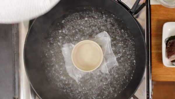 Et maintenant, portez une casserole d'eau à ébullition. Enveloppez le couvercle avec un torchon de cuisine pour éviter que la condensation ne coule.
