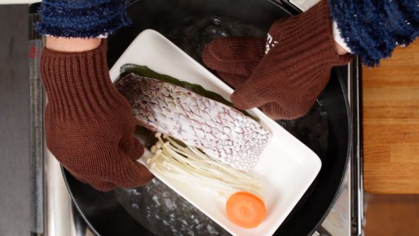 鯛のお皿を鍋に入れ蓋をします。