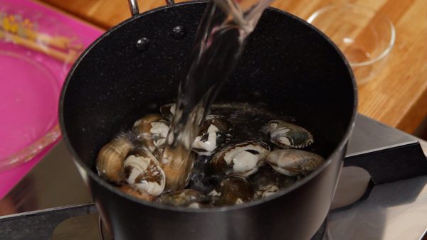 Place the clams in a pot. Add the white wine or sake and 200ml (6.8 fl oz) of water.
