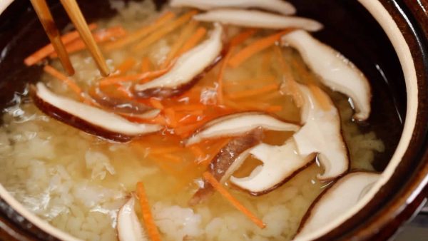 Then, add the sliced shiitake mushroom and shredded carrot.