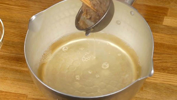 Squeeze out the remaining stock from the bonito flakes using kitchen chopsticks. You can substitute dashi stock powder if kombu and bonito flakes are not available.