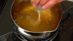 Quand ça commence à bouillir, coupez le feu. Ajoutez petit à petit la fécule de pomme de terre diluée en mélangeant. 