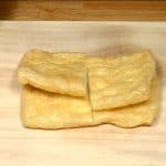 Cut the aburaage, thin deep fried tofu in half.