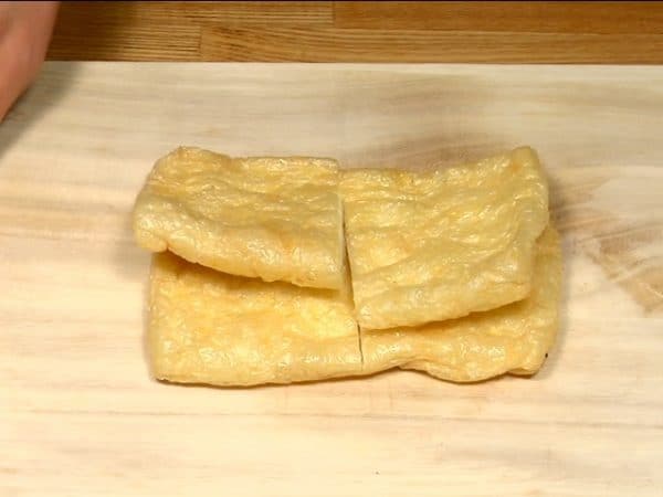 Cut the aburaage, thin deep fried tofu in half.