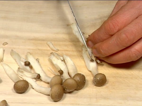 Tear the shimeji mushrooms into smaller pieces and cut enoki mushrooms.