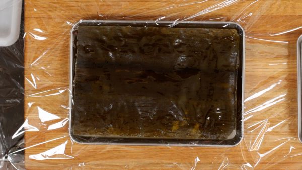 Place one sheet of kombu onto a tray covered with plastic wrap.