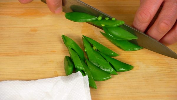 Drain the excess water and slice the bean pods using diagonal cuts.