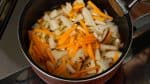 Add the shiitake mushrooms, aburaage, carrot and lotus root and turn on the burner.