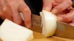 Corta la cebolla a la mitad a lo largo en 4 piezas en el sentido de la fibra, dejando la parte inferior pegada.