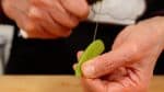 Remove the firm stringy part from the snow pea pods. Pull the string from the stem end to the tip along the pod.