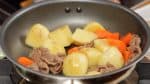 Roerbak alles goed door tot het oppervlak van de aardappels transparant begint te worden. De Ingrediënten goed door koken op dit punt zorgt er voor dat je later minder water toe hoeft te voegen.