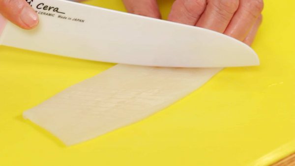 Next, let’s prepare the squid. Make numerous diagonal cuts along the surface. Only make shallow cuts about halfway through the thickness of the squid, making sure not to slice through it.