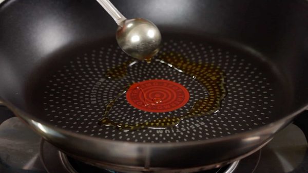 五目あんかけ焼きそばを作ります。蒸し麺は酒または水を加えて600Wの電子レンジで1分加熱してあります。フライパンにサラダ油をひき熱します。
