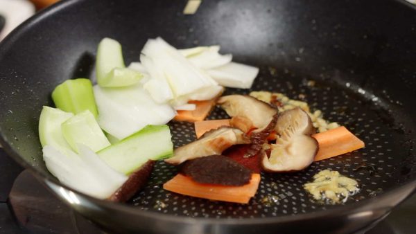 人参、干し椎茸、チンゲン菜と白菜の軸の固い野菜を加えます。