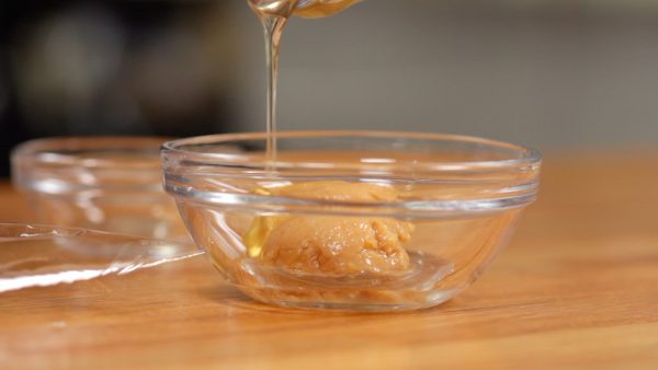 Machen wir als erstes die Miso-Marinade. Miso und Sake verrühren. Wir verwenden hier Honig statt Mirin, der nicht überall leicht erhältlich ist. Das Gericht schmeckt mit Honig genauso gut wie mit Mirin.