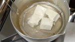 D'abord, préparez le tofu. Déchirez le tofu ferme en bouchées, placez-les dans une casserole d'eau bouillante. Faites mijoter sur feu doux environ 1 minute. 