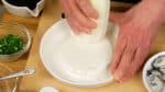 Đầu tiên, bào củ cải daikon bằng bàn nạo. Vỏ củ cải daikon có vị hăng và kết cấu cứng nên loại bỏ nó trước khi chế biến.