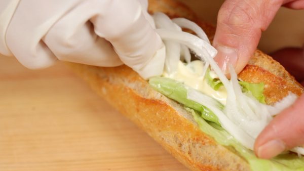 Verwendet für das Sandwich heurige Zwiebel, die nicht so scharf im Geschmack sein sollten und verteilt diese gleichmäßig über das Brot. 