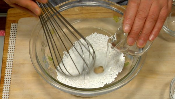 Ahora hagamos el gyuhi, una especie de mochi dulce. Coloca el shiratamako, la harina de arroz dulce en un bol y agrega gradualmente el agua.