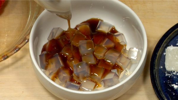 Vierte de forma generosa la salsa Kuromitsu encima de los cubos Kanten.