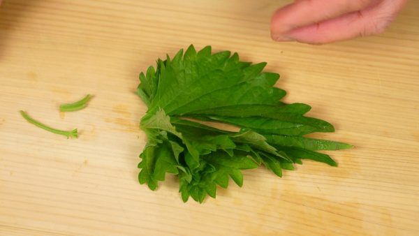Now, let’s cut the vegetables. Remove the stem of the shiso leaves and cut them in half lengthwise. Arrange the shiso leaves around the edge of a plate.