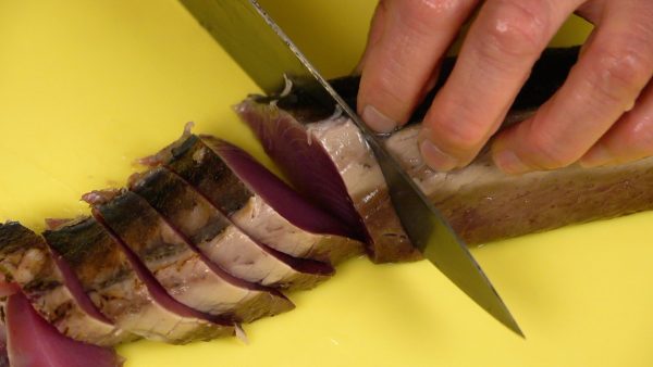 Place the katsuo on a cutting board with the skin side facing up and the thinner side facing you. Gently pulling the knife toward you, slice the katsuo into 1cm (0.4") slices.
