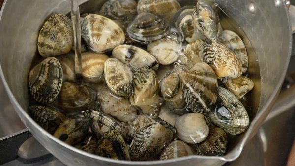 Now, let’s cook the clams. Place the clams into a pot and pour water over them until they’re almost covered.