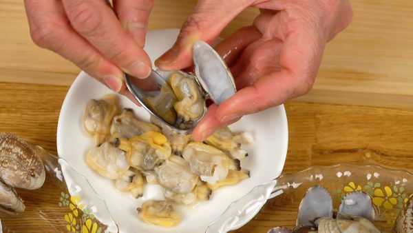 Now, remove the clams from the shells. Using a spoon, scrape off the connecting muscles so that the meat can be removed easily.