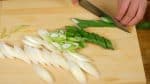 Coupons les légumes. Coupez une longue ciboule en tranches diagonales de 5 mm.
