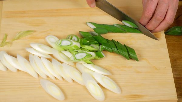 Let’s cut the vegetables. Slice the long green onion into 5 mm (0.2") slices using diagonal cuts.