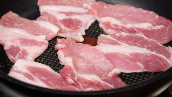 Turn on the burner and add the sesame oil. Arrange the pork slices into the heated pan.
