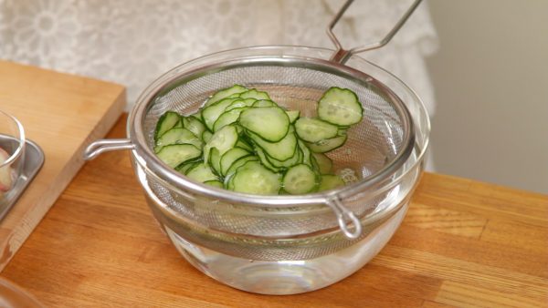 And now, rinse the cucumber slices in a bowl of water. Then, squeeze out the excess moisture.