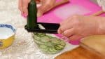 First, with a mandoline slicer, slice the cucumber into a bowl.
