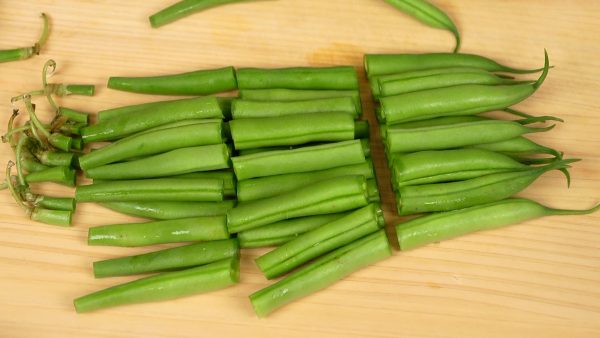 First, let’s prepare the ingen, string bean pods. Remove the stem end. Cut the bean pods into 2 to 3 pieces.