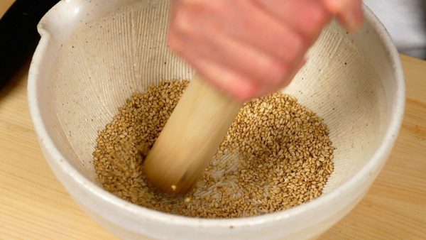 Place the sesame into a suribachi mortar. Then, grind the seeds until they reach the desired consistency.