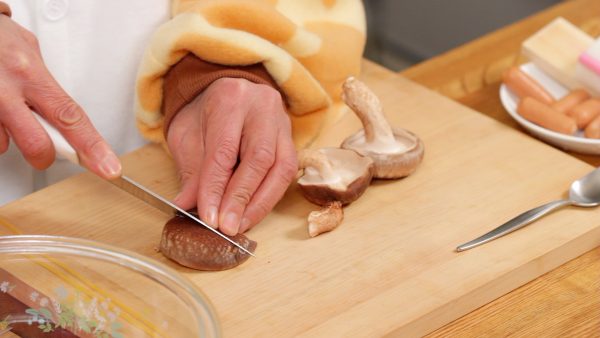 First, let’s prepare the ingredients. Remove the stem of the shiitake mushrooms. Then, slice the caps into bite-size pieces cutting at an angle.