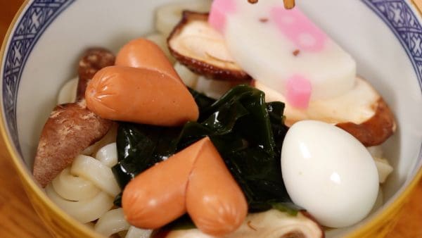 Add the shiitake mushrooms, wakame, sausage, quail eggs, kamaboko and the mitsuba parsley.