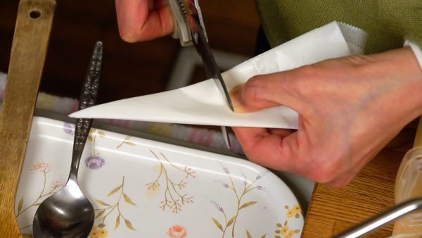 Fold the parchment paper into a wedge and trim off the end and the tip.