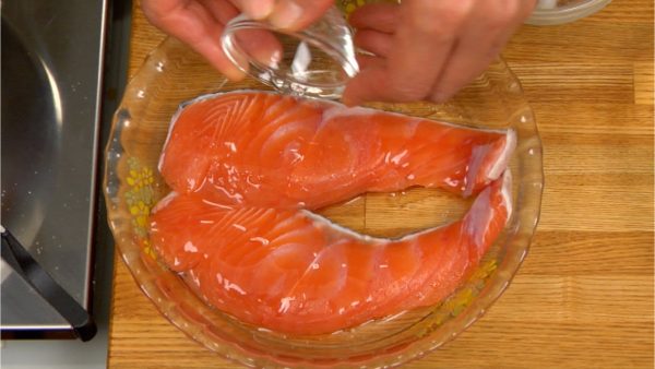 Flip the fillets over and add more salt. Sprinkle on the sake and season the salmon with it evenly.
