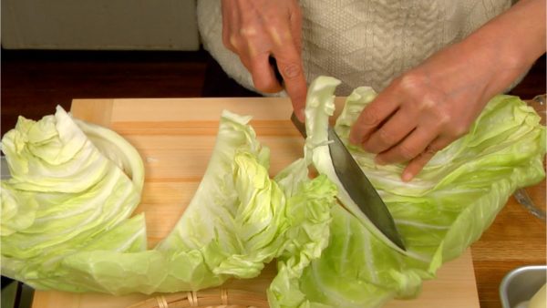 Let's cut the vegetables. Remove the stalks of the cabbage leaves.