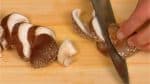 Coupez les pieds des champignons shiitake. Coupez les chapeaux en tranches fines.